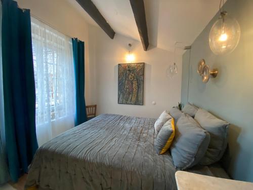 een slaapkamer met een bed en een groot raam bij M&S - Maison FÉRAUD in Saint-Rémy-de-Provence
