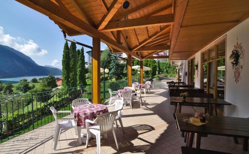 a patio with tables and chairs on a balcony at Charme Hotel Nevada in Molveno