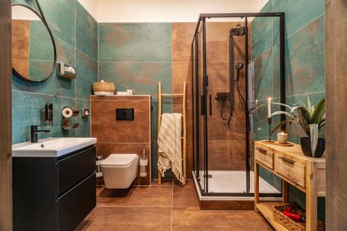 a bathroom with a shower and a toilet and a sink at STING Boutique Apartments in Ostrava