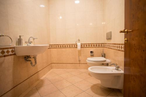 a bathroom with a toilet and a sink at Hotel Golden Palace in Göd