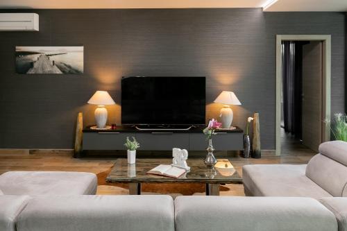 a living room with two couches and a flat screen tv at Korcula Luxury Apartments in Korčula