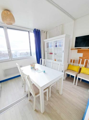 une salle à manger blanche avec une table et des chaises blanches dans l'établissement L'escale - VUE MER, PLAGE, CENTRE VILLE, IDÉAL POUR COUPLE, à Royan