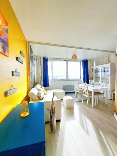 salon z kanapą i stołem w obiekcie L'escale - VUE MER, PLAGE, CENTRE VILLE, IDÉAL POUR COUPLE w mieście Royan