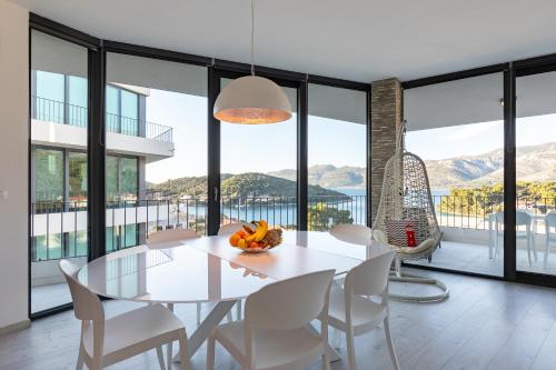 a dining room with a white table and chairs at Korcula Luxury Apartments in Korčula