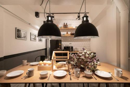 a dining room table with two black lights and plates and a plant at 4 Bedrooms House in Thapae/NightBazaar in Chiang Mai