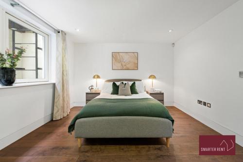 a bedroom with a large bed with a green blanket at Richmond - 1 Bedroom Apartment - With Garden in Kew