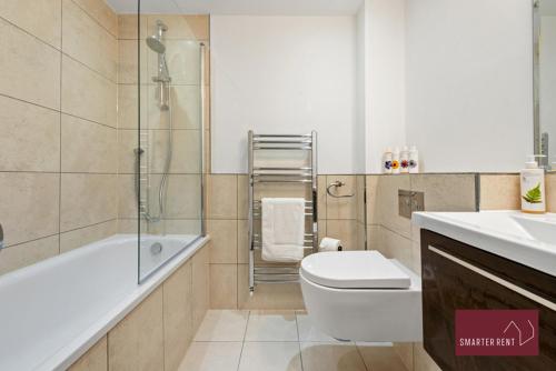 a bathroom with a tub and a toilet and a sink at Richmond - 1 Bedroom Apartment - With Garden in Kew