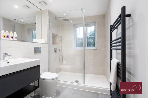y baño con ducha, aseo y lavamanos. en Englefield Green - Modern 2 bedroom Apartment, en Englefield Green