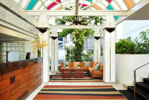 a lobby with chairs and a couch in a building at Oasis Hotel Waikiki in Honolulu