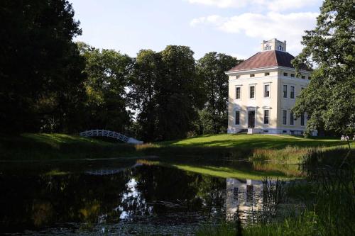 una casa blanca con un reflejo en un estanque en Ferienhaus Familie Berger, en Dessau