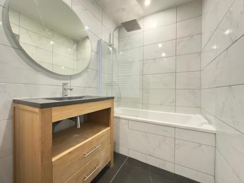 y baño con lavabo, bañera y espejo. en Duplex lumineux Montpellier clim/garage en Montpellier