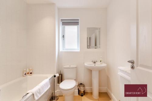 La salle de bains blanche est pourvue de toilettes et d'un lavabo. dans l'établissement Bracknell - 4 Bedroom House - With Driveway, Garden & Garage, à Bracknell