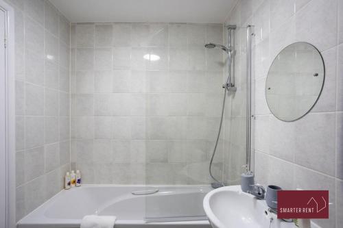 a bathroom with a tub and a sink and a shower at Knaphill - 2 Bedroom House - Garden & Parking in Chobham