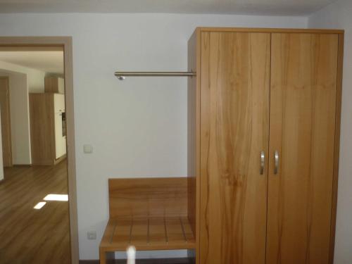 a wooden cabinet in a room next to a door at Ferienwohnungen beim Hotel zur Post, Erlau in Erlau