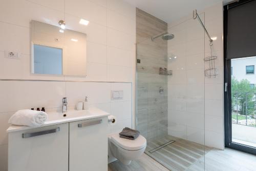 a white bathroom with a toilet and a shower at Korcula Luxury Apartments in Korčula