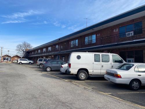 a white van parked in a parking lot in front of a building at Tides Inn at Stehli Beach in Locust Valley