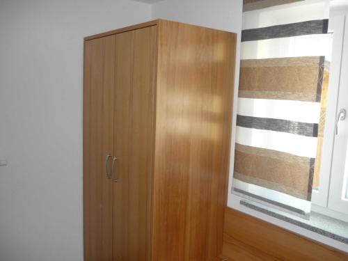 a wooden cabinet in a room with a window at Ferienwohnungen beim Hotel zur Post, Erlau in Erlau