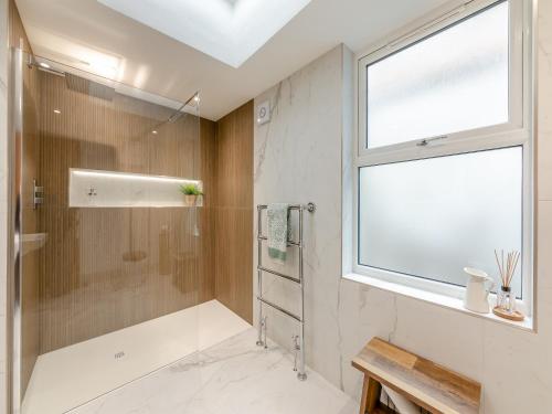 uma casa de banho com um chuveiro e uma janela em The Procession em Berwick-Upon-Tweed