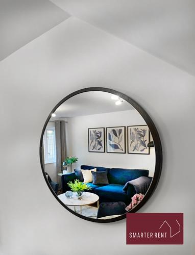 a mirror in a living room with a blue couch at Knaphill - 2 Bedroom Terrace House - With Garden in Brookwood