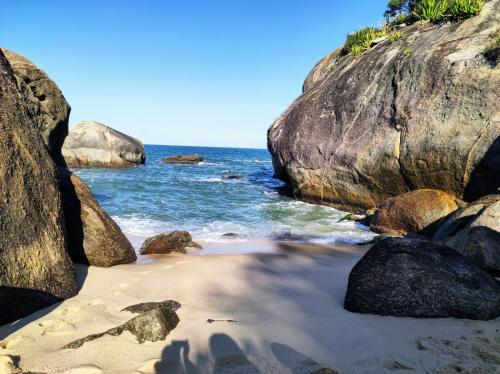 a beach with large rocks and the ocean at Refúgio Azul na Praia - Itaipuaçu-RJ in Maricá