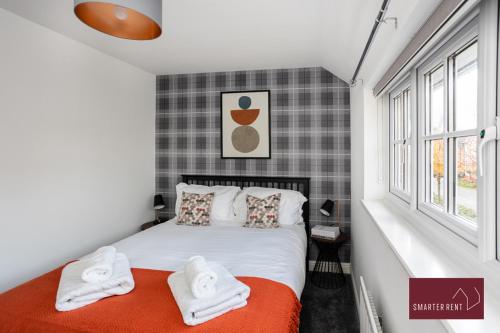 una camera da letto con un letto e asciugamani di Jennett's Park, Bracknell - 2 Bedroom Home - Garden & Parking a Bracknell