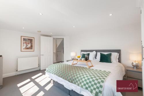 1 dormitorio con 1 cama con manta verde y blanca en Richmond - 2 Bedroom Duplex Apartment, en Richmond upon Thames