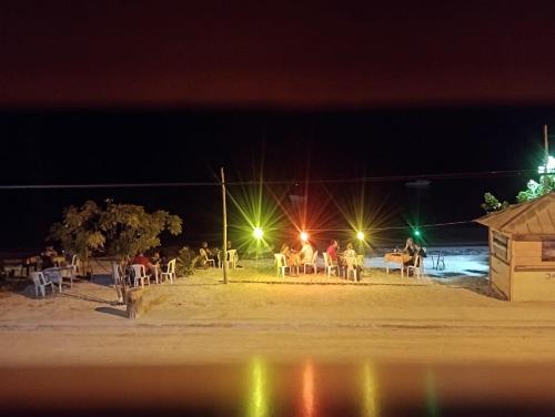 a group of people sitting around a table at night at Tropic ecolodge in Punta Rucia