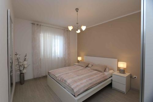 a bedroom with a bed and two lamps and a window at Apartment in Silo/Insel Krk 14599 in Šilo