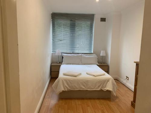 a bedroom with a bed with two pillows on it at Hestia Travel London in London