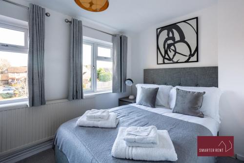 Bracknell - 2 Bedroom Home With Parking & Garden في Easthampstead: غرفة نوم عليها سرير وفوط