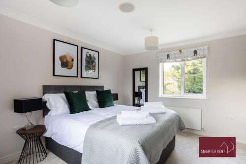 1 dormitorio con 2 camas y ventana en Wimbledon - 4 Bedroom Home With Parking, Garden & Office, en Londres