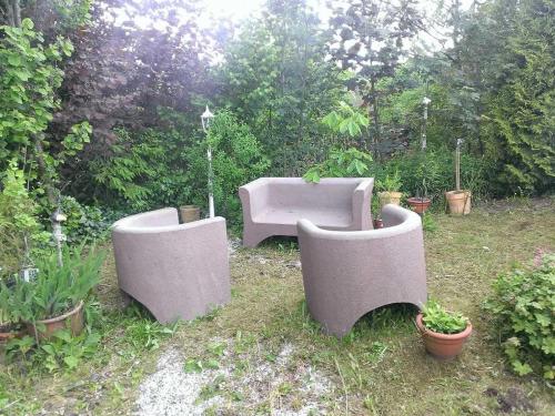 três cadeiras de cimento e um sofá num jardim em Ferienwohnungen Willrich em Blankenheim