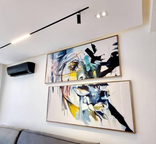 two framed paintings on a wall in a room at Orion_apartments in Lagos