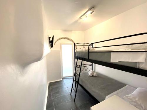 a room with two bunk beds and a doorway at MYKONOS VIBES AIRPORT STUDIOS AND APARTMENTS in Aggelika