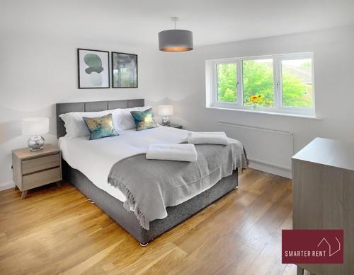 een slaapkamer met een groot bed en een raam bij Guildford - 2 Bedroom House in West Clandon