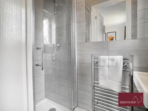 ein Bad mit einer Dusche und einem Waschbecken in der Unterkunft Knaphill, Woking - 3 Bed House - With Garden in Brookwood