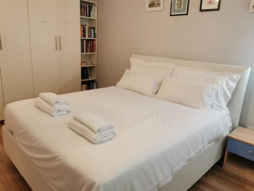 Un dormitorio con una cama blanca con toallas. en PERFECT APARTMENT for centre and Miramare, en Trieste