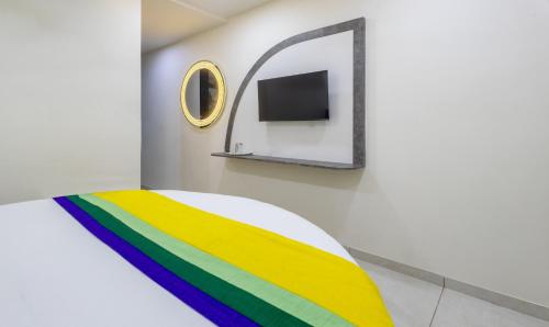 a room with a rainbow bed and a mirror at Itsy Hotels Signature, Nehru Nagar in Ahmedabad