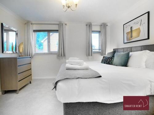 a bedroom with a large white bed and windows at Lightwater - One Bedroom House - With Parking in Bagshot