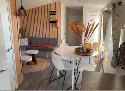 ein Wohnzimmer mit einem Tisch, Stühlen und einem Sofa in der Unterkunft EnJoy Meer und See Ferienhaus -Aan het Lauwersmeer in Lauwersoog -3 Slaapkamers - 1 tot 6 pers -Vanaf 14u al inchecken! Free WIFI! in Lauwersoog