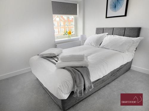 a bedroom with a large bed with white sheets and pillows at Eton, Windsor - 2 Bedroom Second Floor Apartment - With Parking in Eton