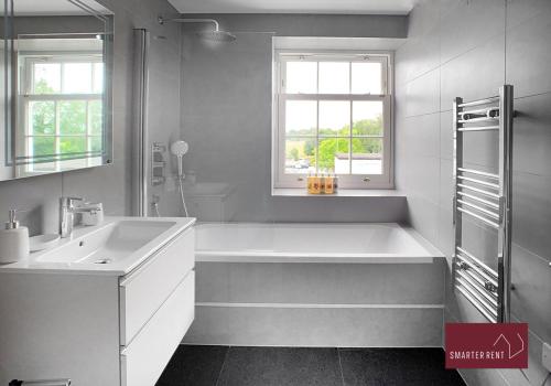 a white bathroom with a tub and a sink at Eton, Windsor - 2 Bedroom Second Floor Apartment - With Parking in Eton