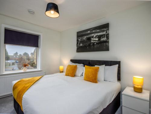 a bedroom with a large white bed with yellow pillows at Perfect For Long Stays With Driveway Parking in Southampton