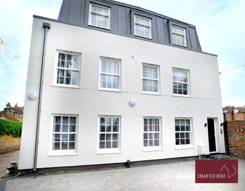 a white building with windows on a street at Eton Windsor - 1 Bedroom Flat - With Parking in Eton