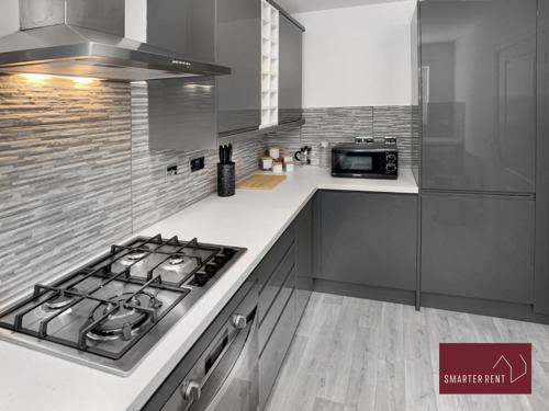 Il comprend une cuisine équipée d'une cuisinière et d'un comptoir. dans l'établissement Wokingham - 2 Bedroom House - With Garden, à Winnersh