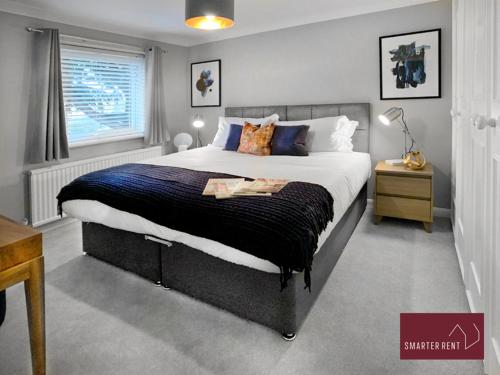 um quarto com uma cama grande e uma janela em Maidenhead- 3 Bedroom House With Garden em Maidenhead