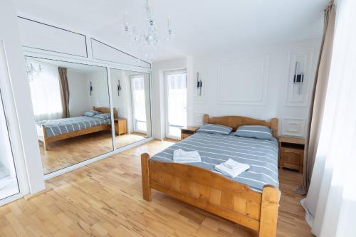 a bedroom with a bed and a mirror at Rivendell Chalet in Valea Ierii