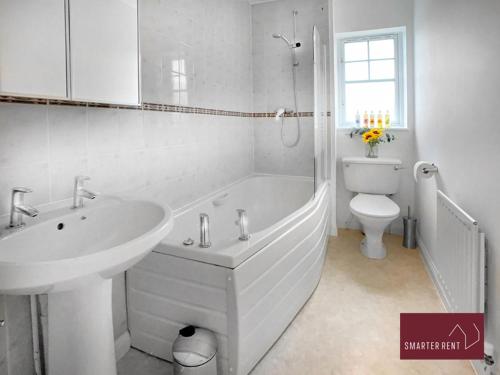 a bathroom with a sink and a tub and a toilet at Bracknell - 2 Bedroom House With Garden and Parking in Easthampstead