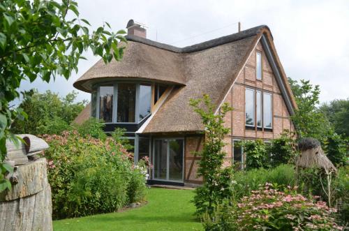 a house with a thatched roof and a garden at Reetgedecktes Espenhaus in Grebin
