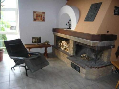 a living room with a fireplace and a chair at Villa Roder in Umkirch